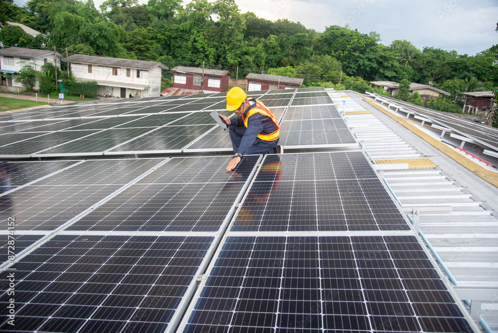 A solar panel installation company employee assembles a photovoltaic system on the roof.