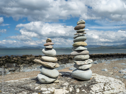 Photography Two piles of zen balanced stones on a sunlit beach