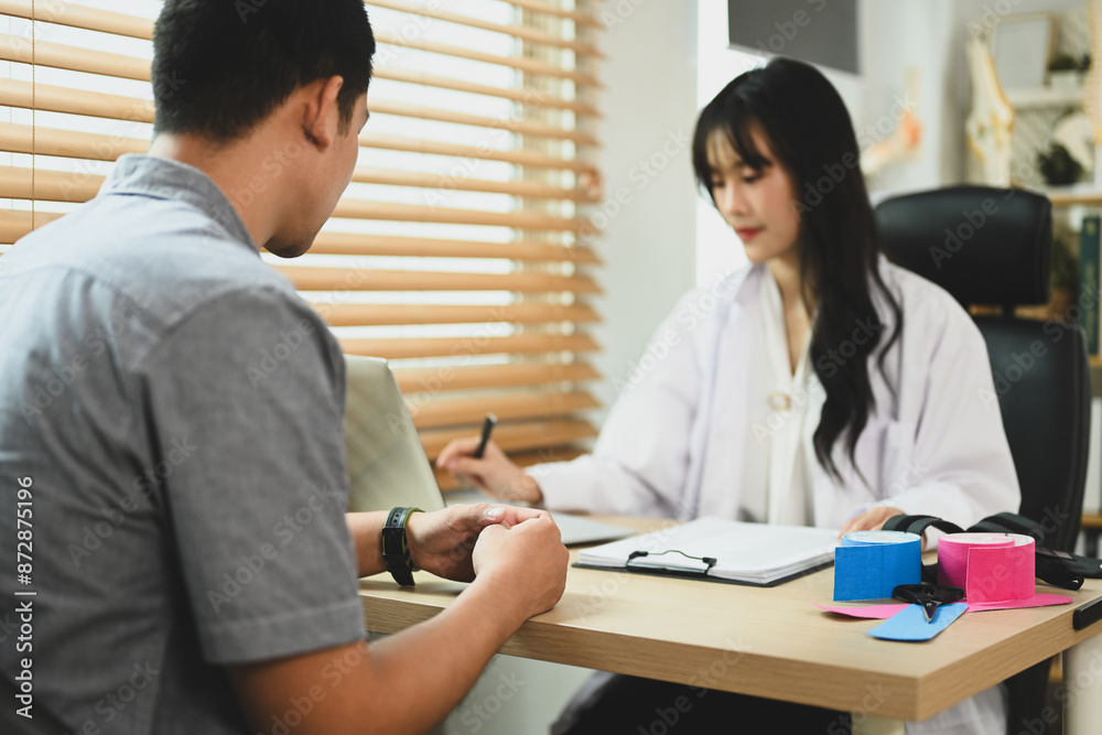 Asian female rehabilitation therapist having a consultation with male patient in clinic Asian female rehabilitation therapist having a consultation with male patient in clinic