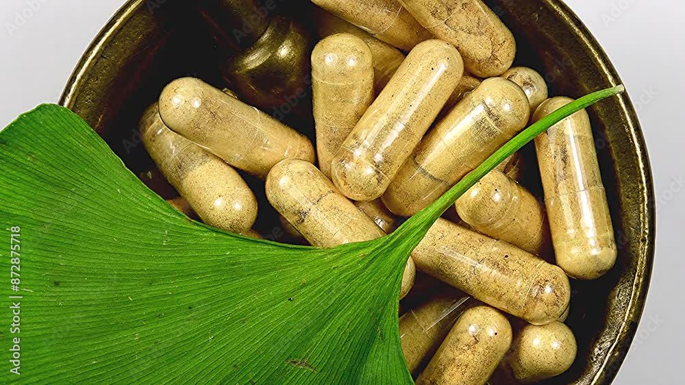 herbal capsules in a mortar with a Ginkgo leaf on a turn table

