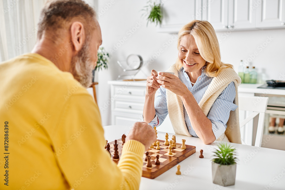 A mature couple in cozy homewear engaged in a game of chess, focusing intently on the board as they strategize their next moves. A mature couple in cozy homewear engaged in a game of chess, focusing intently on the board as they strategize their next moves.