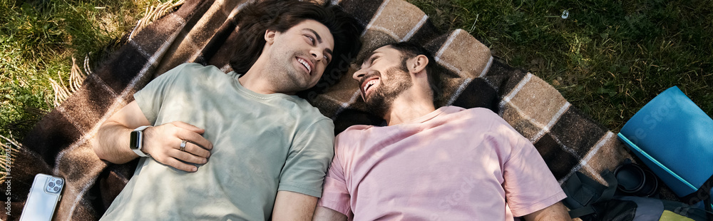 A young gay couple enjoys a sunny summer day while hiking in the wilderness. A young gay couple enjoys a sunny summer day while hiking in the wilderness.