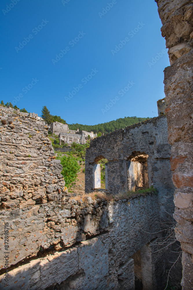 Fototapeta premium Fethiye Kayaköy stone houses and ruins. Mugla, Turkey. Kayakoy ghost village. Turkey's abandoned houses. The Ghost Town of Kayakoy. Abandoned religious ghost city.