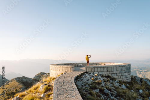 Young woman in Popular tourist attraction of Negosh Mausoleum taking pictures for phone. Tourism, nature, blogging concept. photo