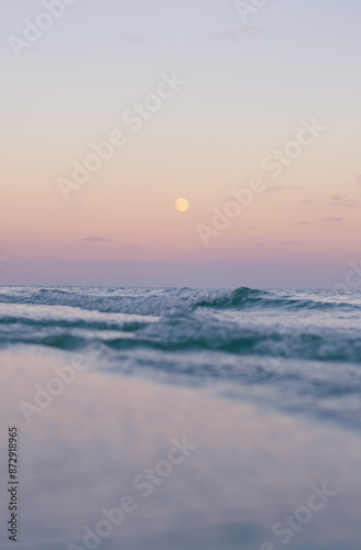 Moon over the ocean during sunset