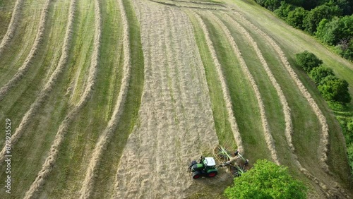 Drohne fliegt über Traktor mit Heuwender, Landwirtschaft, Luftaufnahme photo