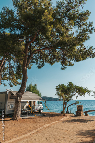 Family traveling with motorhome. Camping in Greece at dawn. Camping holiday at sea. photo