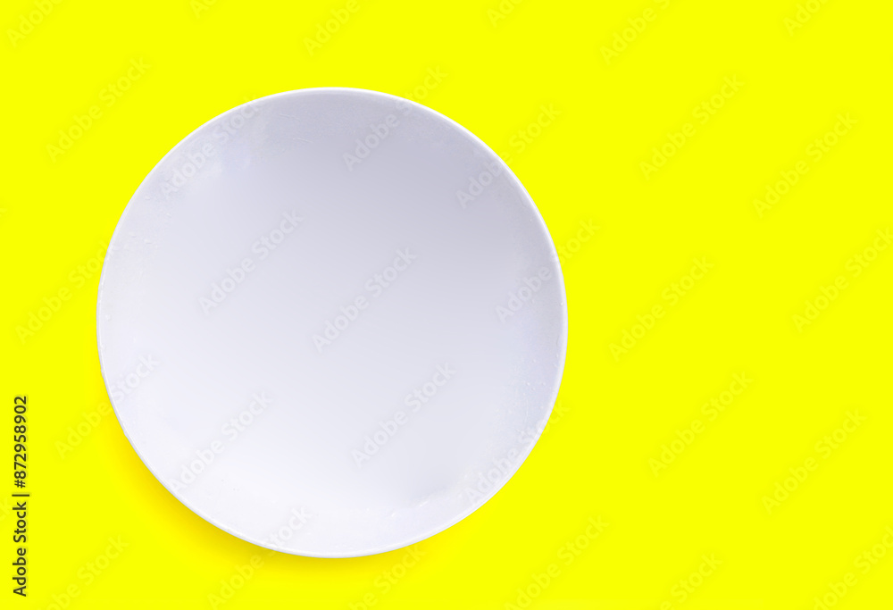 White plate on yellow background White plate on yellow background
