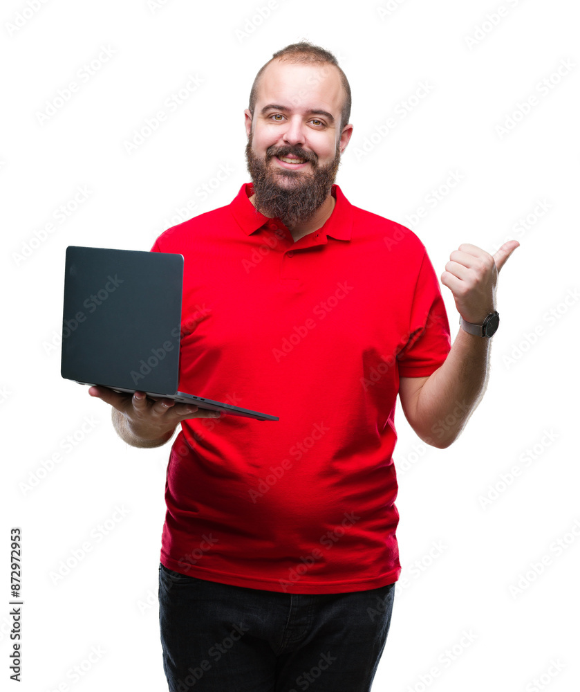 Young caucasian man using computer laptop over isolated background pointing and showing with thumb up to the side with happy face smiling Young caucasian man using computer laptop over isolated background pointing and showing with thumb up to the side with happy face smiling