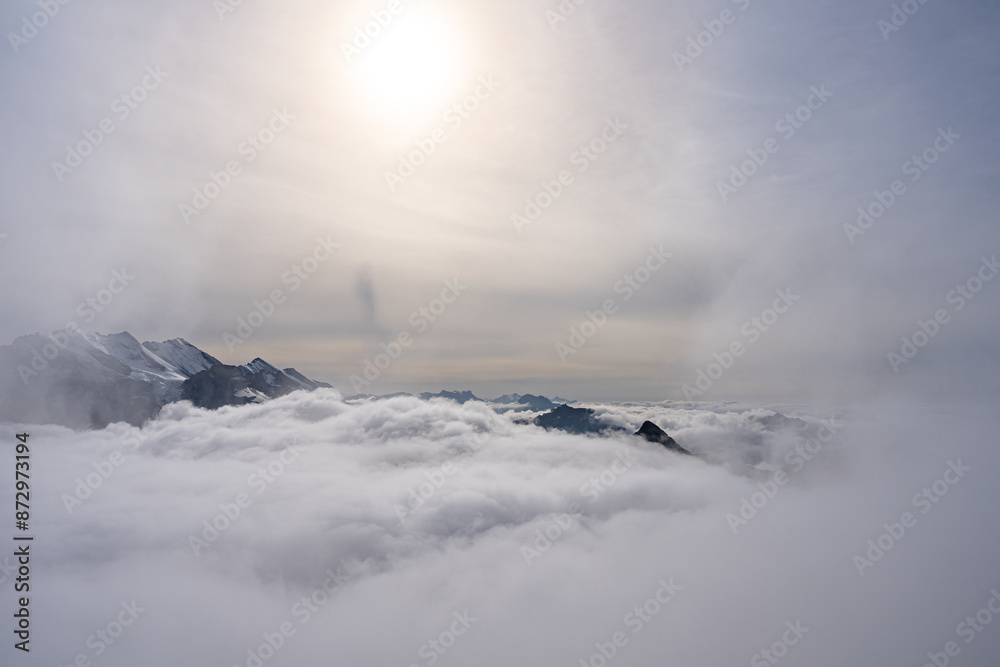 View of Swiss Alps over clouds on a bright sunny day from Schilthorn summit in Switzerland