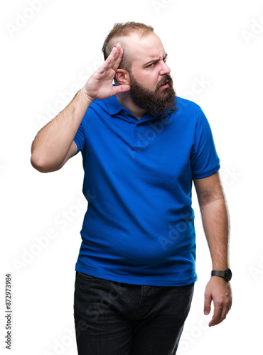 Young caucasian hipster man wearing blue shirt over isolated background smiling with hand over ear listening an hearing to rumor or gossip. Deafness concept.