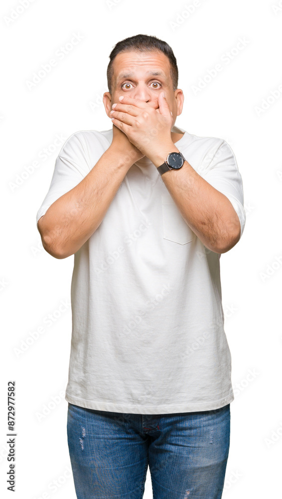 Middle age arab man wearig white t-shirt over isolated background shocked covering mouth with hands for mistake. Secret concept. Middle age arab man wearig white t-shirt over isolated background shocked covering mouth with hands for mistake. Secret concept.