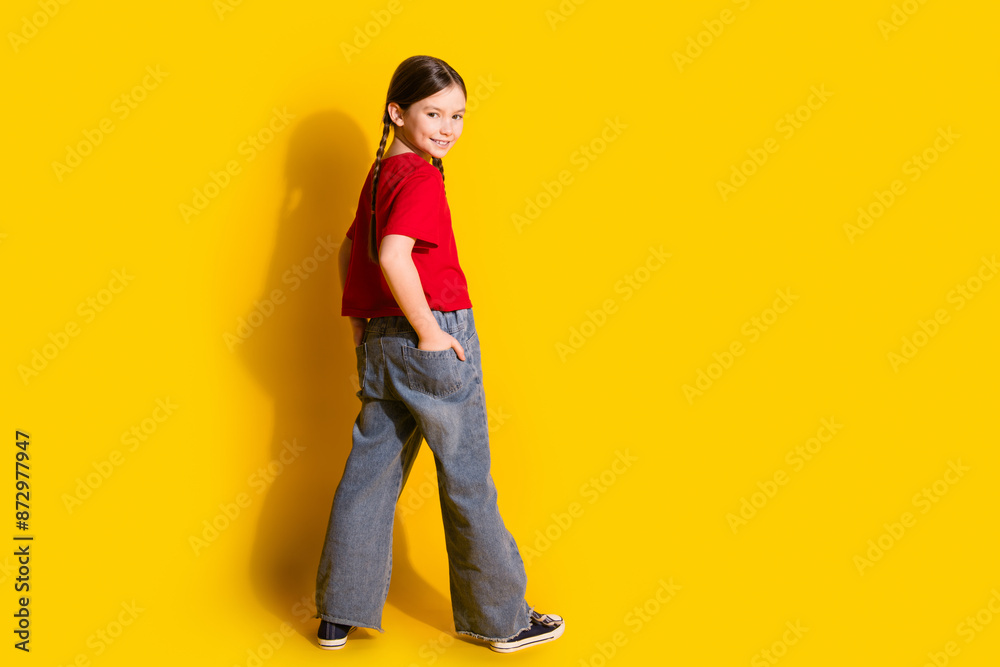 Full length portrait of cute little empty space girl wear t-shirt isolated on yellow color background Full length portrait of cute little empty space girl wear t-shirt isolated on yellow color background