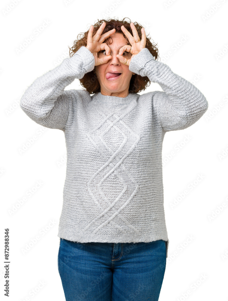 Beautiful middle ager senior woman wearing winter sweater over isolated background doing ok gesture like binoculars sticking tongue out, eyes looking through fingers. Crazy expression. Beautiful middle ager senior woman wearing winter sweater over isolated background doing ok gesture like binoculars sticking tongue out, eyes looking through fingers. Crazy expression.