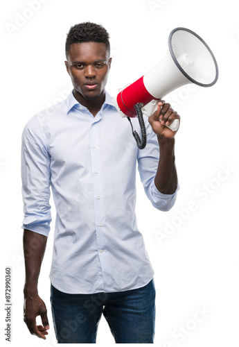 Young african american man holding megaphone with a confident expression on smart face thinking serious