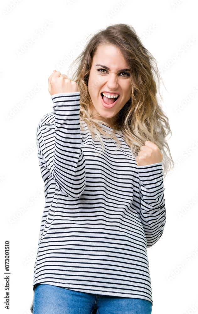 Beautiful young blonde woman wearing stripes sweater over isolated background very happy and excited doing winner gesture with arms raised, smiling and screaming for success. Celebration concept. Beautiful young blonde woman wearing stripes sweater over isolated background very happy and excited doing winner gesture with arms raised, smiling and screaming for success. Celebration concept.