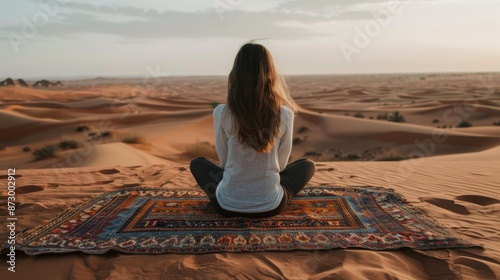 Meditative woman sitting on a rug in a vast desert at sunset, serenity and solitude concept photo