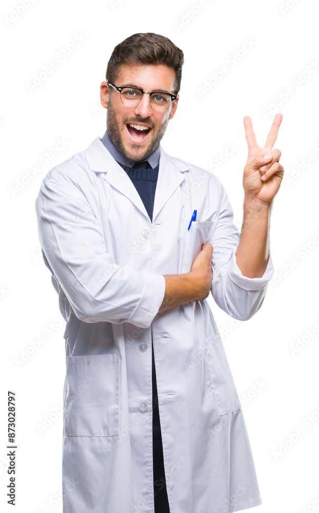 Young handsome man wearing doctor, scientis coat over isolated background smiling with happy face winking at the camera doing victory sign. Number two. Young handsome man wearing doctor, scientis coat over isolated background smiling with happy face winking at the camera doing victory sign. Number two.