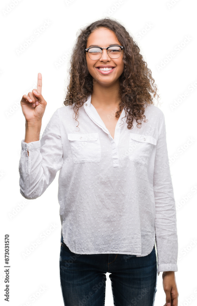 Beautiful young hispanic woman showing and pointing up with finger number one while smiling confident and happy. Beautiful young hispanic woman showing and pointing up with finger number one while smiling confident and happy.