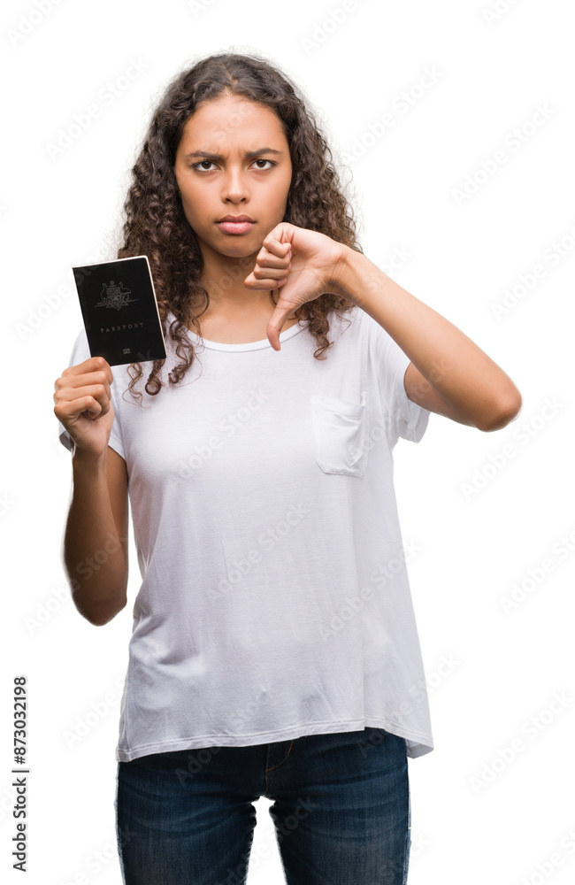 Young hispanic woman holding passport of Australia with angry face, negative sign showing dislike with thumbs down, rejection concept Young hispanic woman holding passport of Australia with angry face, negative sign showing dislike with thumbs down, rejection concept
