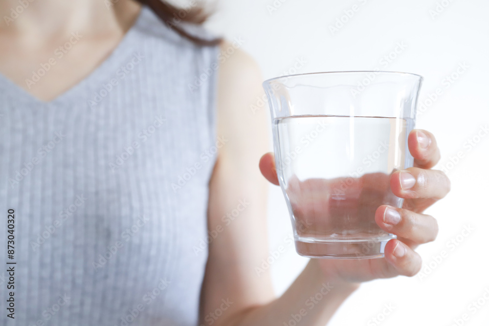 コップに入った水を持つ女性 コップに入った水を持つ女性