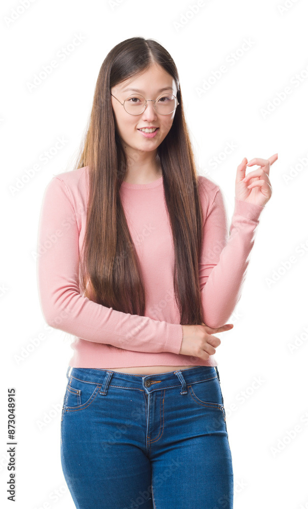 Young Chinese woman over isolated background wearing glasses with a big smile on face, pointing with hand and finger to the side looking at the camera. Young Chinese woman over isolated background wearing glasses with a big smile on face, pointing with hand and finger to the side looking at the camera.