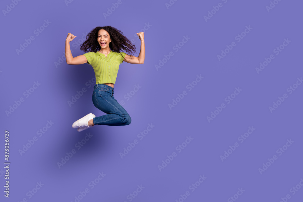 Full body photo of attractive teen woman jump winning dressed stylish green clothes isolated on purple color background Full body photo of attractive teen woman jump winning dressed stylish green clothes isolated on purple color background