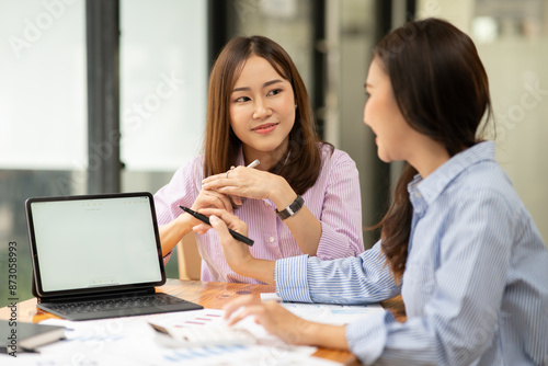 Business women Discuss and plan work on graph documents at the office.