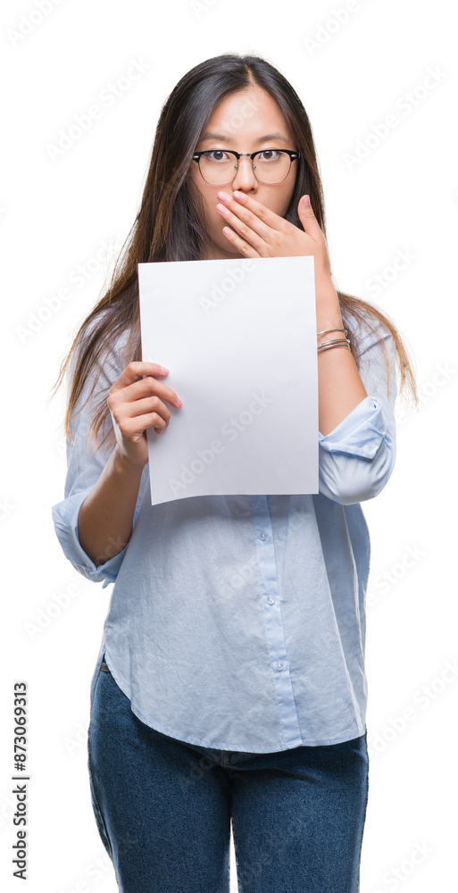 Young asian woman holding blank paper over isolated background cover mouth with hand shocked with shame for mistake, expression of fear, scared in silence, secret concept Young asian woman holding blank paper over isolated background cover mouth with hand shocked with shame for mistake, expression of fear, scared in silence, secret concept
