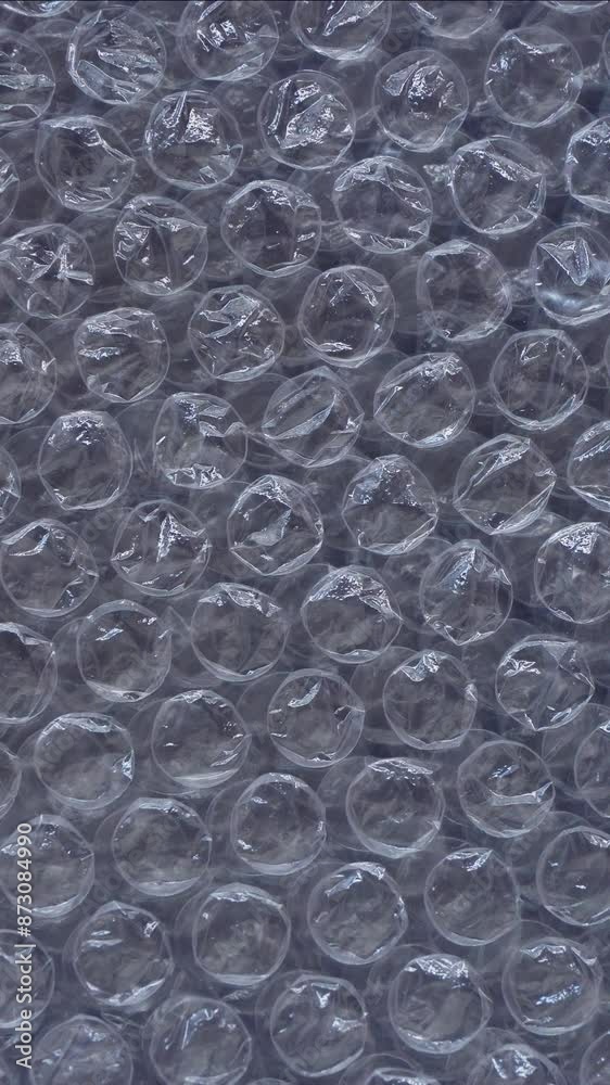 Rotating bubble wrap close-up. Top view plastic bubbles texture background. 4k vertical concept Rotating bubble wrap close-up. Top view plastic bubbles texture background. 4k vertical concept