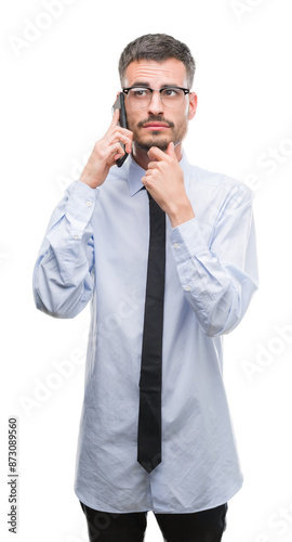 Young business adult man talking on the phone serious face thinking about question, very confused idea