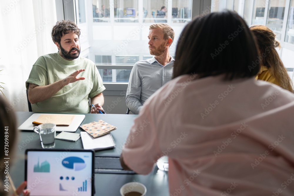 Businessman discussing new ideas with colleagues in office Businessman discussing new ideas with colleagues in office