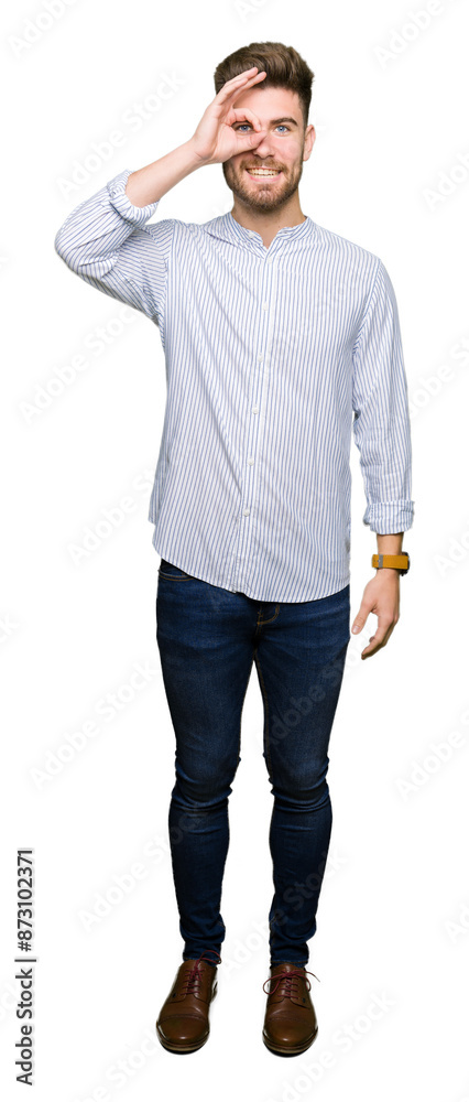 Young handsome man doing ok gesture with hand smiling, eye looking through fingers with happy face. Young handsome man doing ok gesture with hand smiling, eye looking through fingers with happy face.