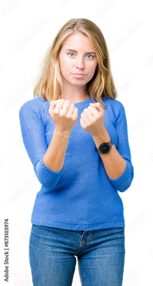 Beautiful young woman wearing blue sweater over isolated background Ready to fight with fist defense gesture, angry and upset face, afraid of problem Beautiful young woman wearing blue sweater over isolated background Ready to fight with fist defense gesture, angry and upset face, afraid of problem