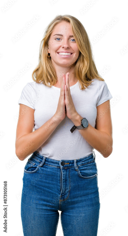Beautiful young woman wearing casual white t-shirt over isolated background praying with hands together asking for forgiveness smiling confident. Beautiful young woman wearing casual white t-shirt over isolated background praying with hands together asking for forgiveness smiling confident.