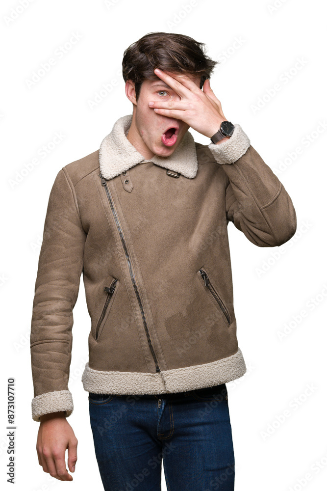 Young handsome man wearing winter coat over isolated background peeking in shock covering face and eyes with hand, looking through fingers with embarrassed expression. Young handsome man wearing winter coat over isolated background peeking in shock covering face and eyes with hand, looking through fingers with embarrassed expression.