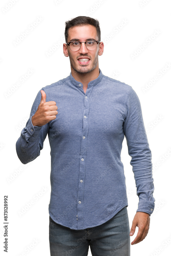 Handsome young elegant man wearing glasses doing happy thumbs up gesture with hand. Approving expression looking at the camera with showing success. Handsome young elegant man wearing glasses doing happy thumbs up gesture with hand. Approving expression looking at the camera with showing success.