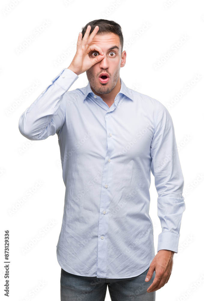 Handsome young businessman doing ok gesture shocked with surprised face, eye looking through fingers. Unbelieving expression. Handsome young businessman doing ok gesture shocked with surprised face, eye looking through fingers. Unbelieving expression.