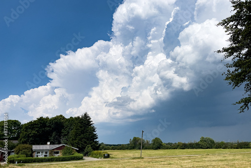 Heavy stormclouds approaching a lonely farmhouse in a rural Danish landscape