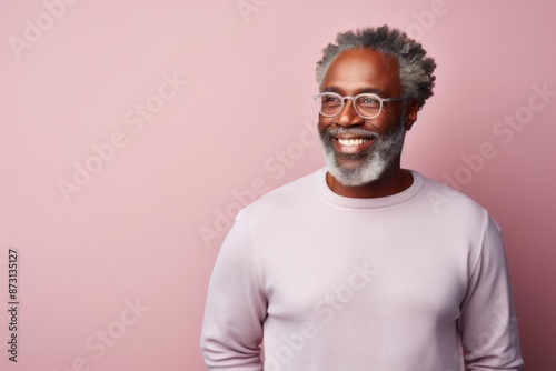 Portrait of a joyful afro-american man in his 60s sporting a long-sleeved thermal undershirt while standing against pastel gray background