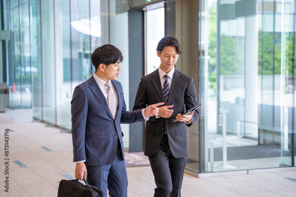 歩きながら打ち合わせをする男性ビジネスマン