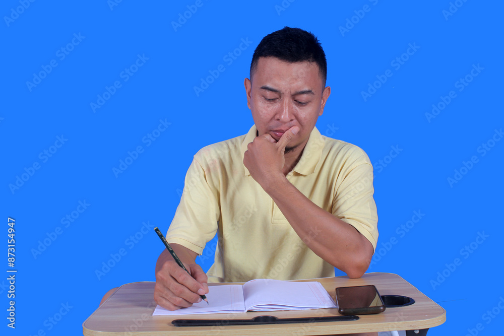 handsome mature asian man using his smartphone confused and dizzy looking for ideas while doing homework at his desk. handsome mature asian man using his smartphone confused and dizzy looking for ideas while doing homework at his desk.