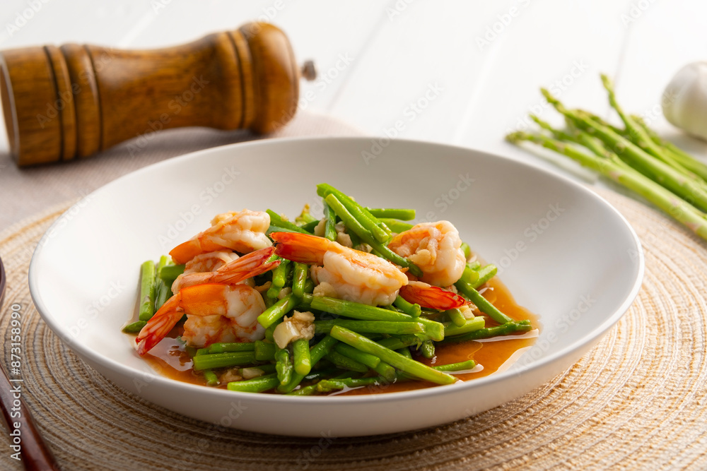 Stir fry asparagus and shrimp with garlic in oyster sauce in white plate. Stir fry asparagus and shrimp with garlic in oyster sauce in white plate.