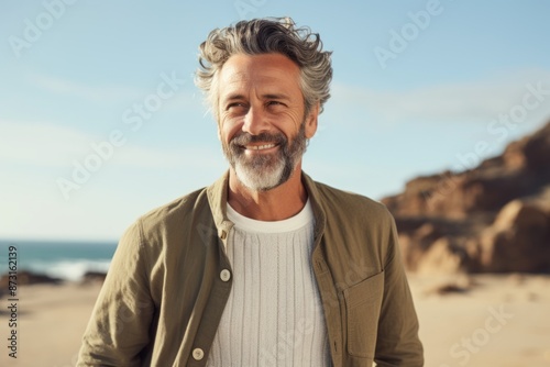 Portrait of a joyful man in his 40s wearing a chic cardigan on sandy beach background