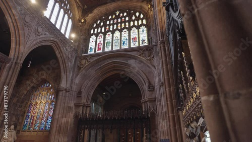 The interior of Manchester Cathedral, adorned with Gothic-themed ornaments such as stained glass windows and statues, complemented by its majestic pipe organ photo