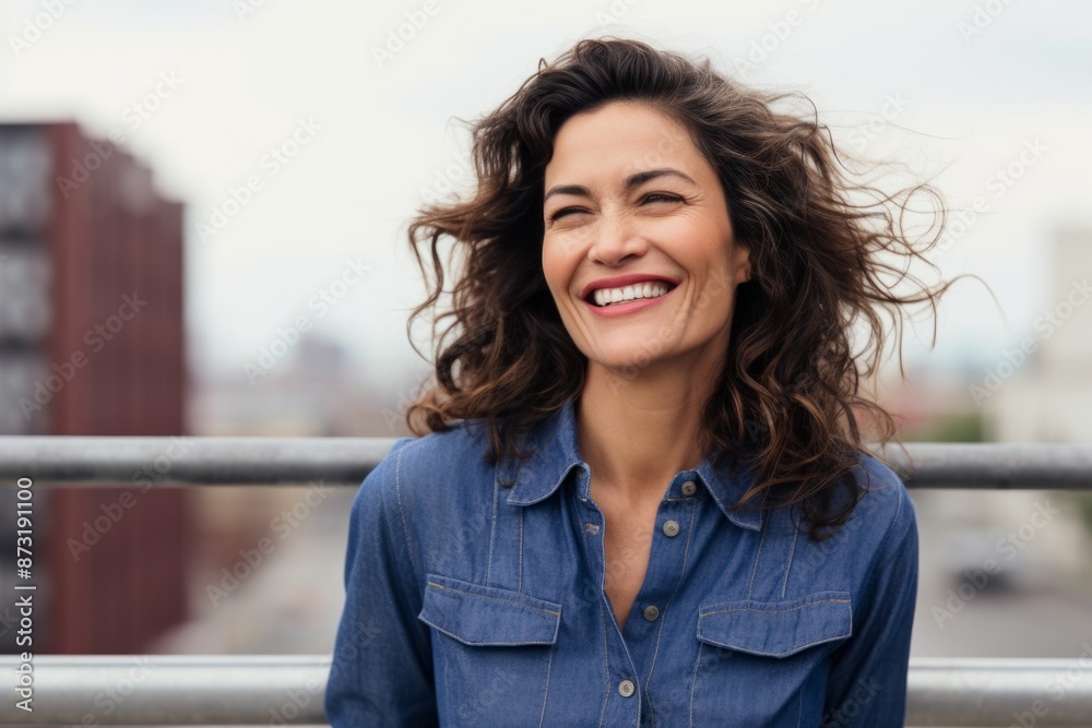 Portrait of a blissful woman in her 40s sporting a versatile denim shirt in front of modern cityscape background Portrait of a blissful woman in her 40s sporting a versatile denim shirt in front of modern cityscape background