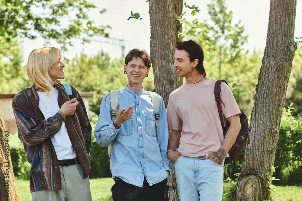 Three queer friends, are walking in a park. They are all dressed casually and seem to be having a conversation. Three queer friends, are walking in a park. They are all dressed casually and seem to be having a conversation.