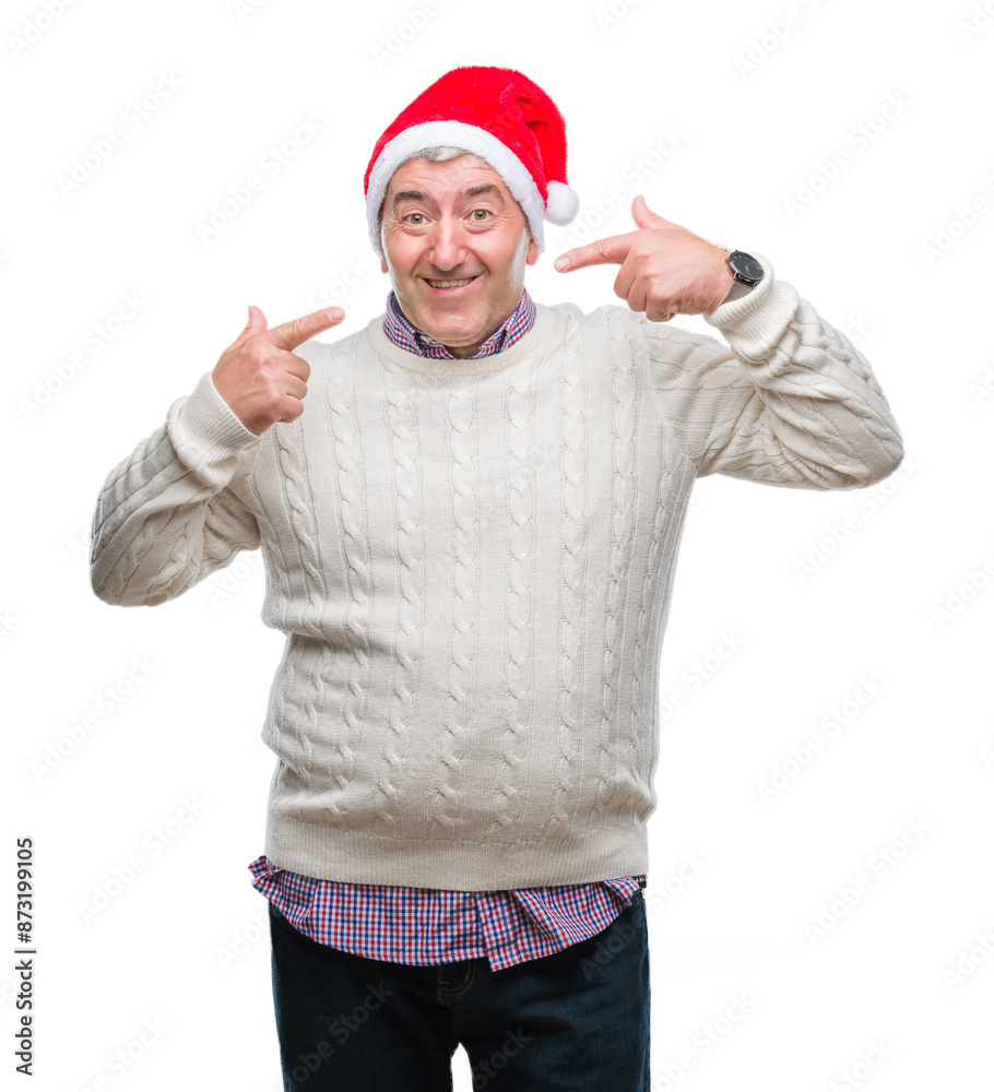 Naklejka premium Handsome senior man wearing christmas hat over isolated background smiling confident showing and pointing with fingers teeth and mouth. Health concept.
