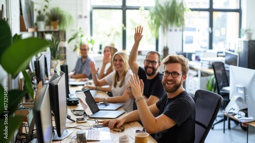 Professional business people smiling to camera while raising hands and wearing causal cloth. Group of multicultural marketing team looking at camera while standing at creative modern office. AIG53F.