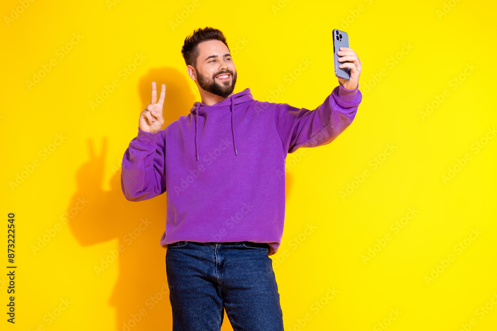 Photo of attractive glad man blogger wear trendy clothes make selfie v-sign isolated on yellow color background Photo of attractive glad man blogger wear trendy clothes make selfie v-sign isolated on yellow color background